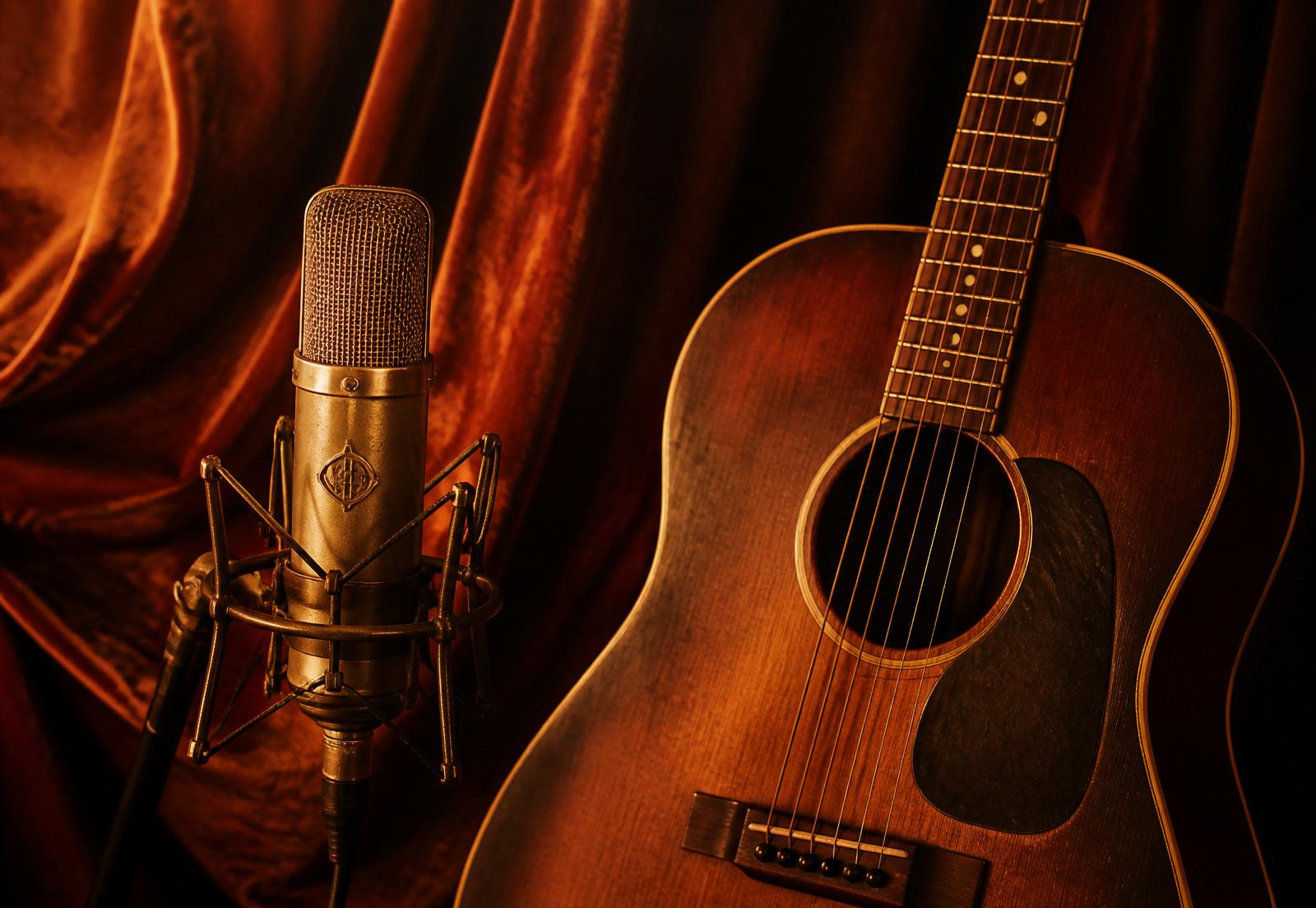 Vintage microphone and acoustic guitar bathed in warm light